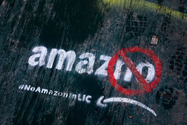 FILE- In this Nov. 16, 2018, file photo graffiti has been painted on a sidewalk by someone opposed to the location of an Amazon headquarters in the Long Island City neighborhood in the Queens borough of New York. Amazon said Thursday, Feb. 14, 2019, that it will not be building a new headquarters in New York, a stunning reversal after a yearlong search. The online retailer has faced opposition from some New York politicians, who were unhappy with the tax incentives Amazon was promised. (AP Photo/Mark Lennihan, File)