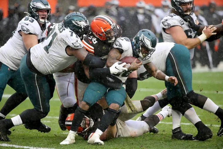 Jason Peters, left, tried to help Eagles running back Miles Sanders (right) as he was tackled by Cleveland Browns defensive tackle Sheldon Richardson during the third quarter,