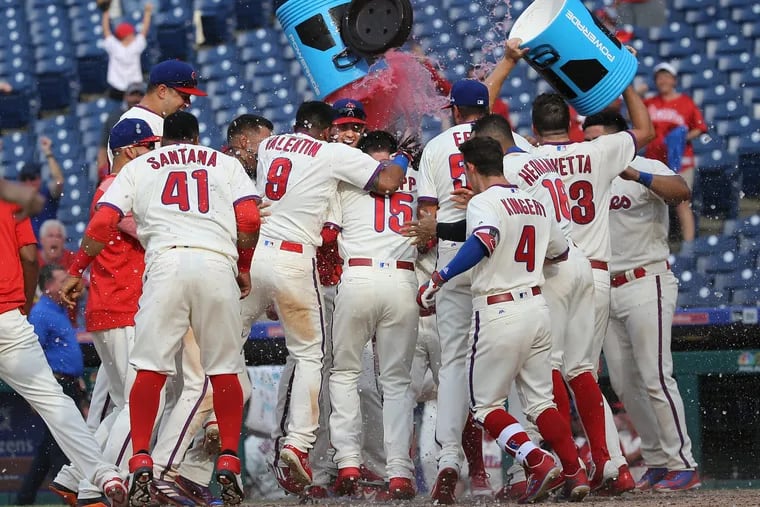 The Phillies surround Andrew Knapp, center, at home plate and celebrate his walk-off homer against the Nationals.