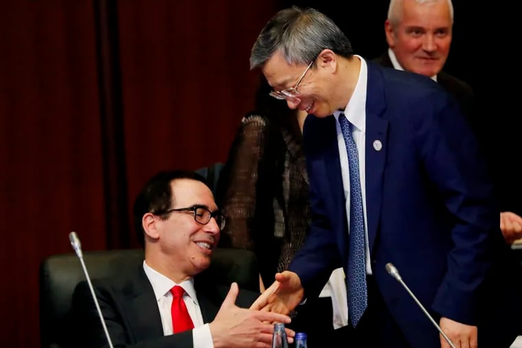China's Central Bank Governor Yi Gang shakes hands with U.S. Treasury Secretary Steve Mnuchin, left, during the G20 Finance Ministers and Central Bank Governors Meeting Saturday, June 8, 2019, In Fukuoka, Japan.
