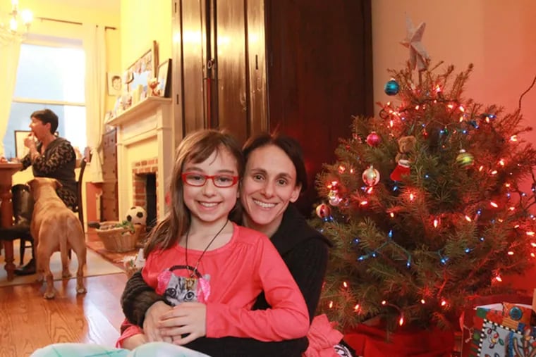 Lara Kelly and her daughter Harper Leary with their tree in Northern Liberties. (David Swanson / Staff Photographer)
