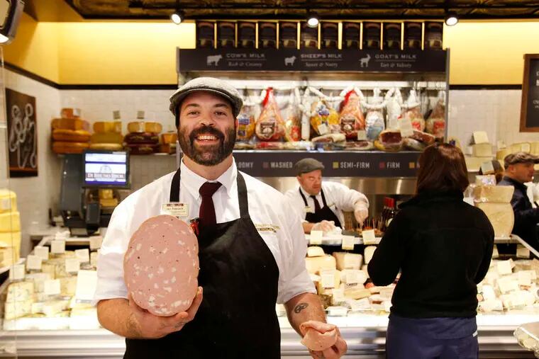 Ian Peacock of Di Bruno Bros. holds a truffled mortadella in the company's new store in the Franklin.
