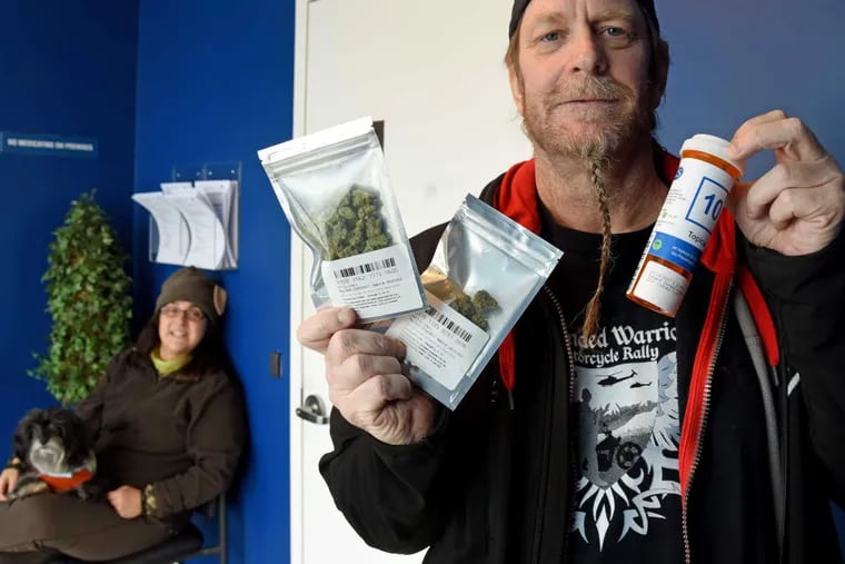Don Karpowich displays his medical marijuana - $328 worth of packets of Lavender and Blue Dream cannabis buds and cannabis extract topical oil (right) - after picking up a prescription at Compassionate Sciences dispensary in Bellmawr March 15, 2017. At left is his wife, Ines, with his therapy dog, Riley.