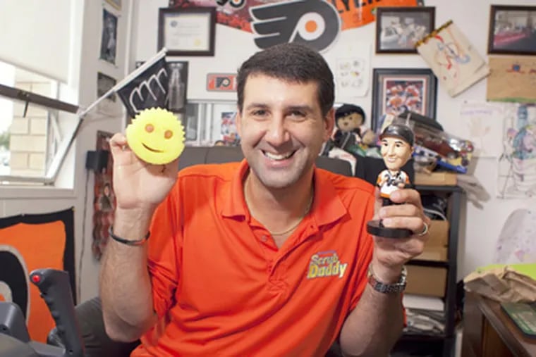 Aaron Krause, a loyal Flyers fan and a fixture at games, holds a bobblehead of himself. (Ed Hille / Staff Photographer)