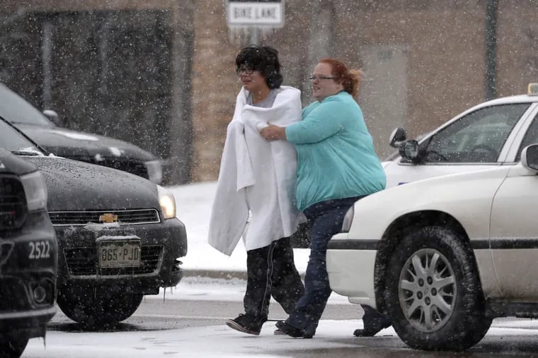 Amid reports of a shooter , a person is escorted to safety in Colorado Springs. Confusion lasted through the afternoon over whether the gunman was at large or holed up at the facility with staff and patients. ANDY CROSS / Denver Post via AP
