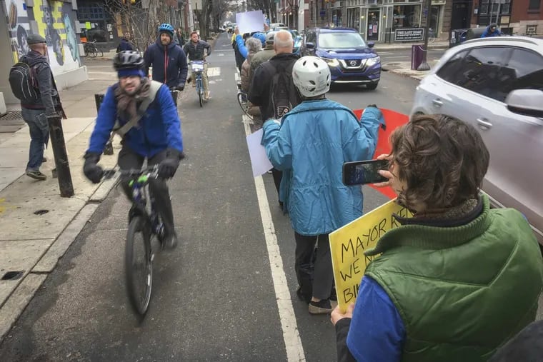 Bicycle commuters are protected from vehicle traffic by a group of protected bicycle lane supporters along S. 13th St. at Pine in Center City Philadelphia on Tuesday, December 19, 2017. Last Friday a cyclist was injured in a collision with a vehicle. On November 29, 2017 a cyclist was killed in a collision with a garbage truck. ALEJANDRO A. ALVAREZ / Staff Photographer