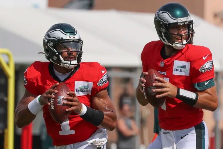Eagles quarterbacks Jalen Hurts (1) and Joe Flacco (7) look before throwing the ball during a drill at training camp at the NovaCare Complex in South Philadelphia on Saturday, Aug. 7, 2021.