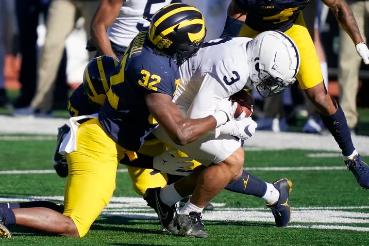 Penn State wide receiver Parker Washington is tackled by Michigan's Jaylen Harrell on Saturday.