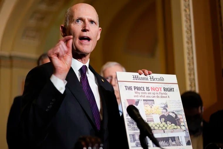Sen. Rick Scott, R-Fla., holds a printed out copy the Miami Herald newspaper during a news conference after a weekly Republican policy luncheon on Capitol Hill in Washington, Tuesday, Dec. 7, 2021.(AP Photo/Carolyn Kaster)