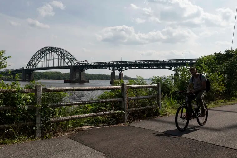 A cyclist rides along the newly opened half-mile connector trail starting at the base of the Tacony-Palmyra Bridge in Philadelphia on Friday, Aug. 11, 2023.