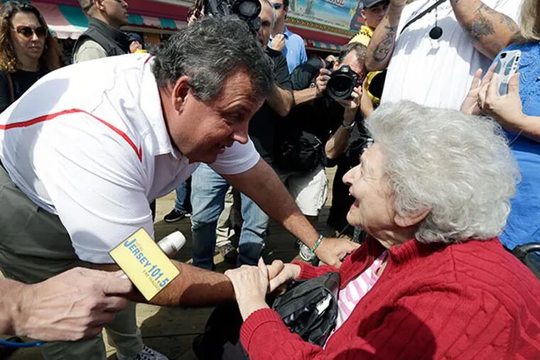 New Jersey Gov. Chris Christie talks to Nancy Masterson, of Union, N.J., during a visit to the Seaside Park boardwalk two days after a massive fire burned a large portion of the boardwalk, Saturday, Sept. 14, 2013, in Seaside Park, N.J. (AP Photo/Julio Cortez)