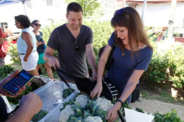 Craig Elliott and Erica Nardello shop at Drum's Produce. The market, at Broad and Mount Vernon Streets, even invites visitors to participate, via iPad, in a mental-health screening. ( MICHAEL BRYANT / Staff Photographer )