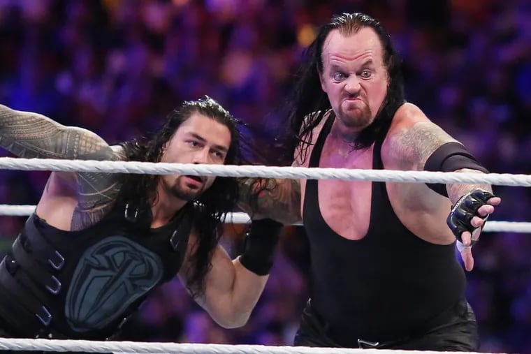 The Undertaker, right, throws Roman Reigns during WrestleMania 33 at Camping World Stadium in Orlando in 2017.