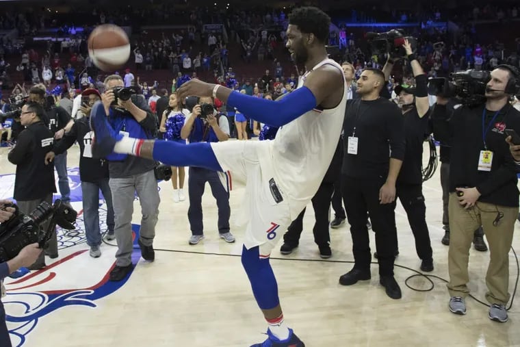 Joel Embiid of the 76ers kicks a souvenir ball into the stands after clinching win over Miami in first round of the NBA playoffs..