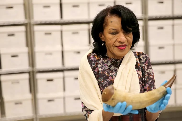 Denise Dennis holds the carved powder horn of her ancestor, Gershom Prince, a black soldier who served and died in the Revolutionary War.