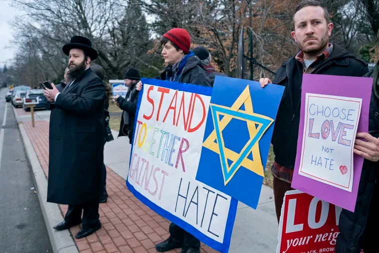 Neighbors gather to show their support of the community near a rabbi's residence in the Orthodox community of Monsey, N.Y., Sunday, following a stabbing Saturday night during a Hanukkah celebration. (AP Photo/Craig Ruttle)
