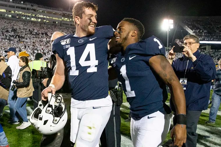 Penn State quarterback Sean Clifford walks with wide receiver KJ Hamler to celebrate with fans after their team defeated Michigan, 28-21, at Penn State's Beaver Stadium on Saturday, Oct. 19, 2019.