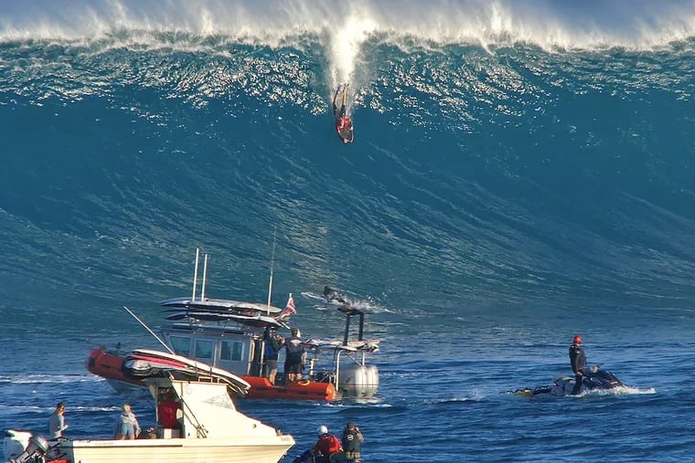 Ambler's Andrew Karr, 22, rides a big wave on a body board in Hawaii.