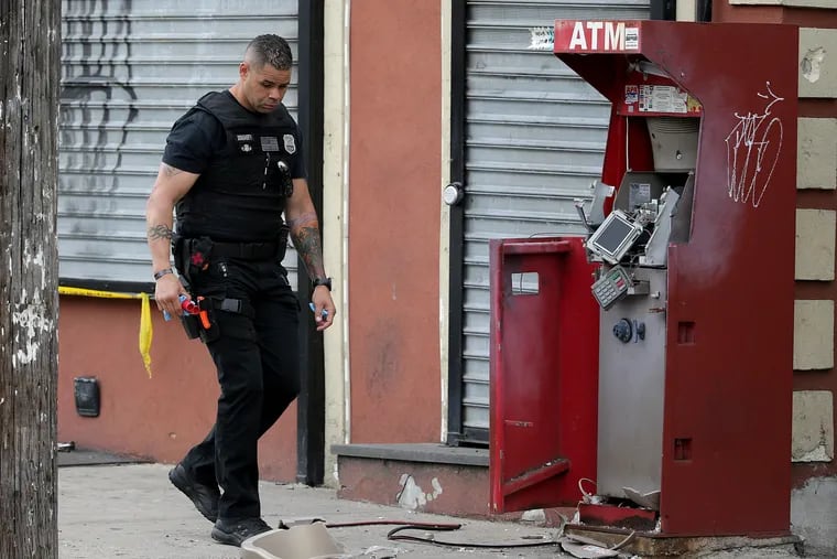 A member of the Philadelphia bomb squad surveys the scene after an ATM machine was blown-up at 2207 N. 2nd St. in Philadelphia on June 2, 2020.