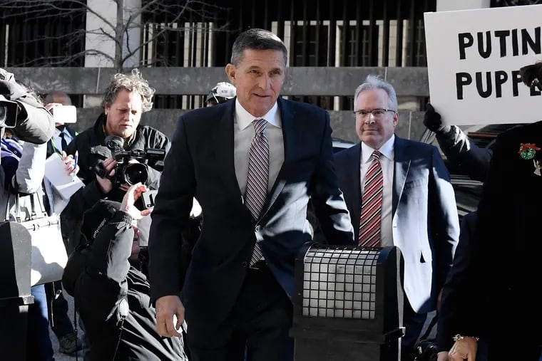 Former National Security Advisor Michael Flynn arrives at U.S. District Court for his sentencing hearing as demonstrators for and against him hold signs outside the courthouse entrance in Washington in December.