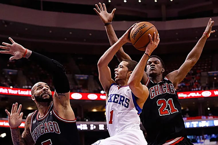 The 76ers' Michael Carter-Williams goes up for a shot against the Bulls' Carlos Boozer and Jimmy Butler. (Matt Slocum/AP)