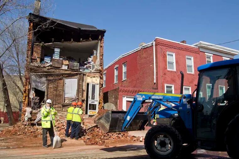 The Ali family complained for years that the city of Camden should have assisted them in making their home structurally sound after they knocked down the house next door. Late last night their home collapsed at 443 Line Street in Camden. Clean up continues on Mar. 9, 2015.  (Charles Fox / Staff Photographer)
