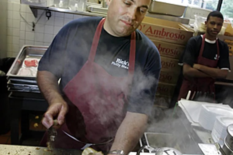 Rick Olivieri serving up a cheesesteaks at Rick's Steaks at Reading Terminal Market last July. Although Rick's finished No. 30 on WIP's list, that was higher than Geno's or Pat's.