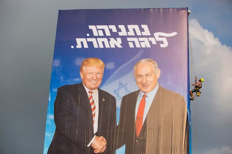 A worker hangs an election campaign billboard of the Likud party shows Israeli Prime Minister Benjamin Netanyahu, right, and US President Donald Trump in Bnei Brak, Israel, Sunday, Sept 8, 2019. Hebrew on the billboard reads "Netanyahu, in another league". (AP Photo/Oded Balilty)