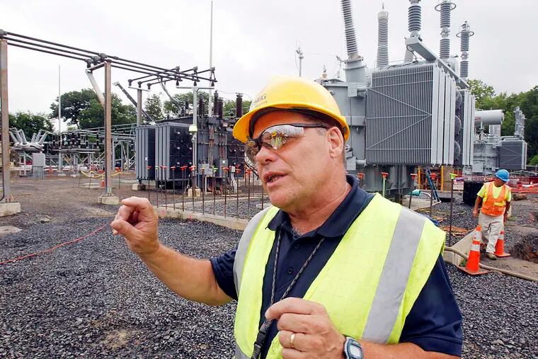 Steve Maginnis, a project manager at PSE&G's Cuthbert Substation, in front of an old transformer (left) and a new one. Work began at the site last August and is to continue through next June.