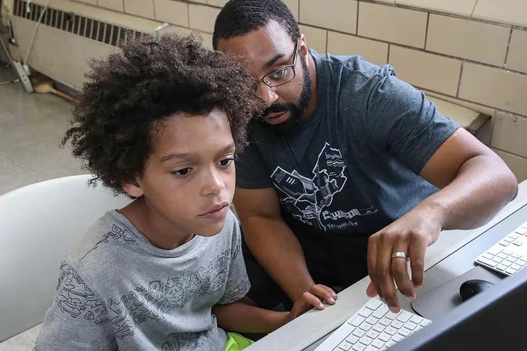 Sylvester Mobley works with Marlowe Whittenberg, 8, at a Coded by Kids workshop at the Marian Anderson Recreation Center. Coded by Kids is a nonprofit offering technology classes at city recreation centers for young people ages 5 to 18.