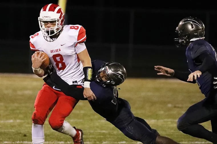 Delsea quarterback Mason Maxwell (left) fights a tackle by Timber Creek’s Sage Brown on Friday.