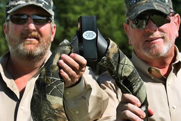 When Greg Jackson (left) and Mike Willis of Wylie, Texas, heard about someone driving around with one of their Original Off-Road Commodes attached to the bumper, they decided to use 'Not For Use On Moving Vehicles' labels, May 21, 2009. (Louis DeLuca / Dallas Morning News / MCT)