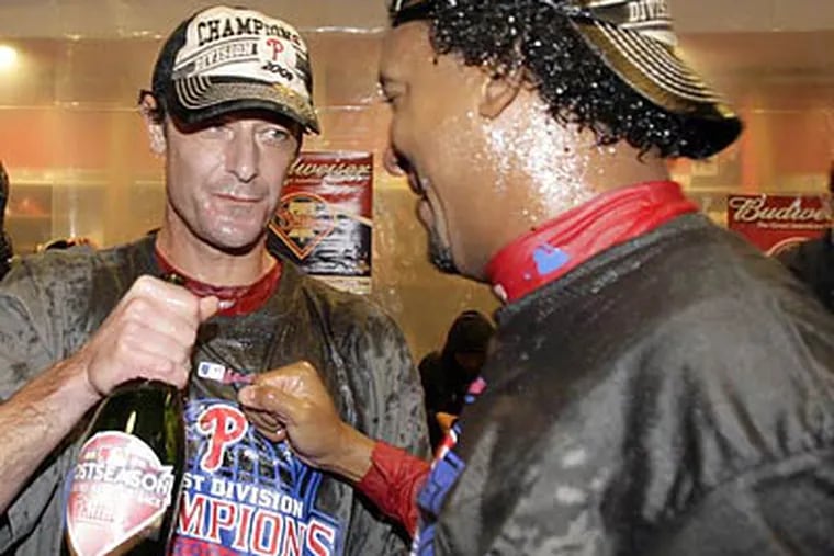 Jamie Moyer and Pedro Martinez celebrated together in the locker room after the Phillies clinched their third straight National League East division title. (Yong Kim/Staff Photographer)