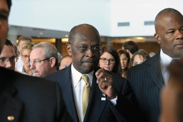 Republican presidential candidate Herman Cain, center, is surrounded by security and staff as he walks through a hotel lobby in Alexandria, Va., Wednesday, Nov. 2, 2011, before speaking after meeting with doctors attending the Docs4PatientCare conference. (AP Photo/Cliff Owen)