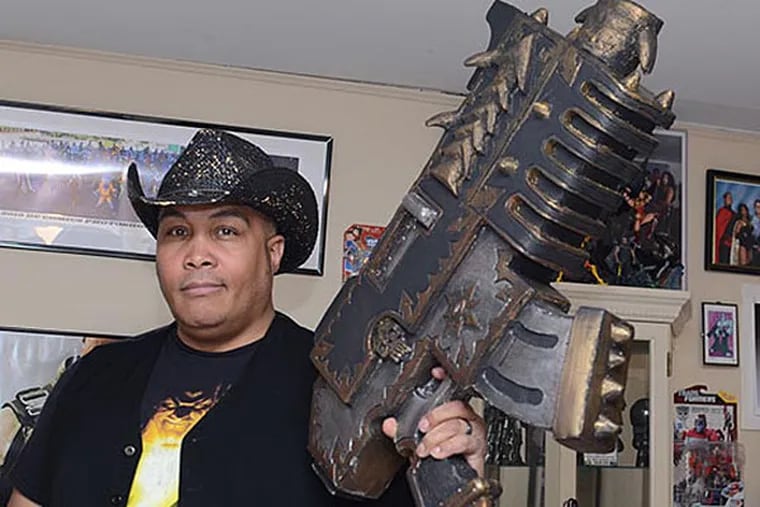 Eric "Smoke" Moran holds a prop gun from his Warhammer cosplay.  Moran has over 200 different cosplay costumes.  (Andrew Thayer / Staff Photographer)
