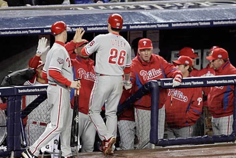 Chase Utley is greeted at the dugout after hitting his second homerun in the 6th inning of Game 1 of the 2009 World Series at Yankee Stadium. (David Maialetti / Staff Photographer)