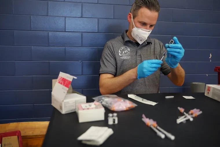 Marc Ost, co-owner of pharmacy Eric's RX Shoppe, prepares doses of the Pfizer COVID-19 vaccine during a vaccination clinic for children 12 and older at Cheltenham High School in Wyncote, Pa., on Wednesday, May 19, 2021.