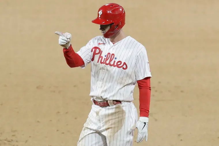 Phillies Rhys Hoskins points to his teammates against the New York Mets on Monday, April 5, 2021 in Philadelphia.