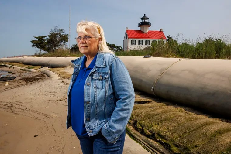 Nancy Patterson with the Maurice River Historical Society on the beach in front of the East Point Lighthouse in Heislerville, N.J. Behind here are geotextile tubes use to help against beach erosion.