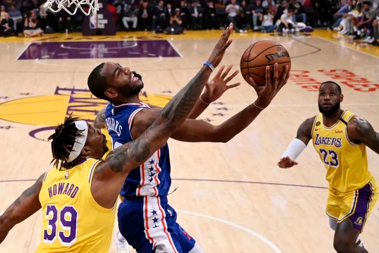 76ers guard Alec Burks shoots as Lakers center Dwight Howard (left) and forward LeBron James defend during the first half.