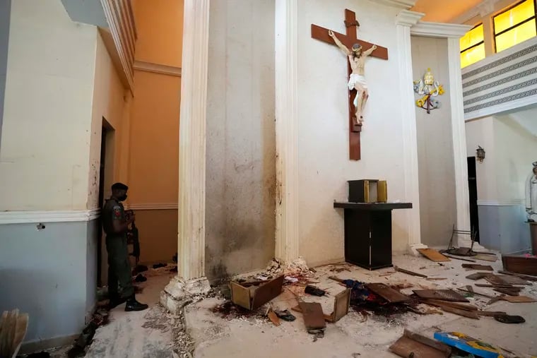 A police officer stands guard inside the St. Francis Catholic Church, a day after an attack that targeted worshipers in Owo, Nigeria. The gunmen who killed 50 people at a Catholic church in southwestern Nigeria opened fire on worshippers both inside and outside the building in a coordinated attack before escaping the scene, authorities and witnesses said Monday.