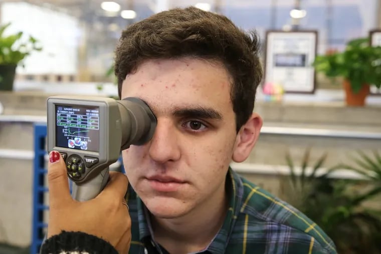 Max Brandt, a 10th grader who suffered a concussion while playing soccer, has his pupil reaction checked by a researcher from Children’s Hospital of Philadelphia.