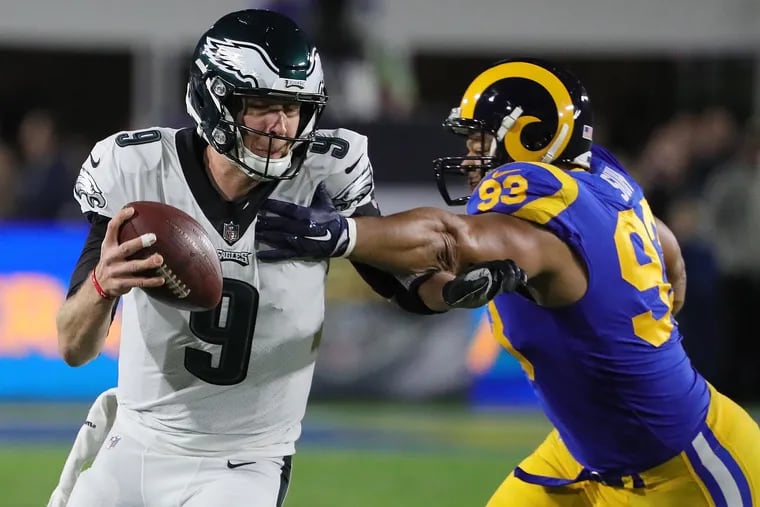 Nick Foles (left) tries to avoid the Rams' Ndamukong Suh on Sunday.