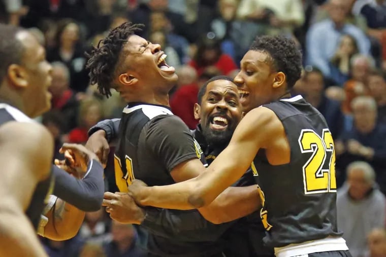 Lincoln coach Al Brown (center) and players Aseem Luckey (left center) and Tyree Corbett celebrate after defeating Hazleton, 76-74, in overtime.