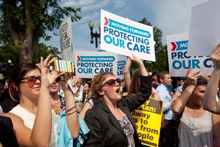 Demonstrators react to the Supreme Court landmark decision on health care, Thursday, June 28, 2012, outside the court in Washington.  (AP Photo/Evan Vucci)