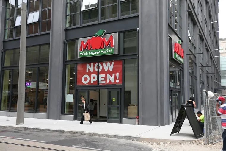 A shopper exits MOM’s Organic Market which opened Sept. 8 at East Market.