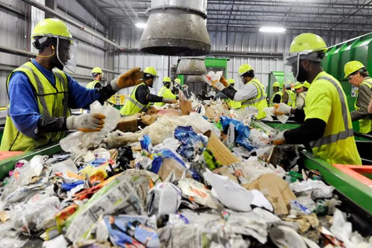 In an expensive process, workers remove by hand nonrecyclables from items that can be recycled. (RON TARVER/File Photo)