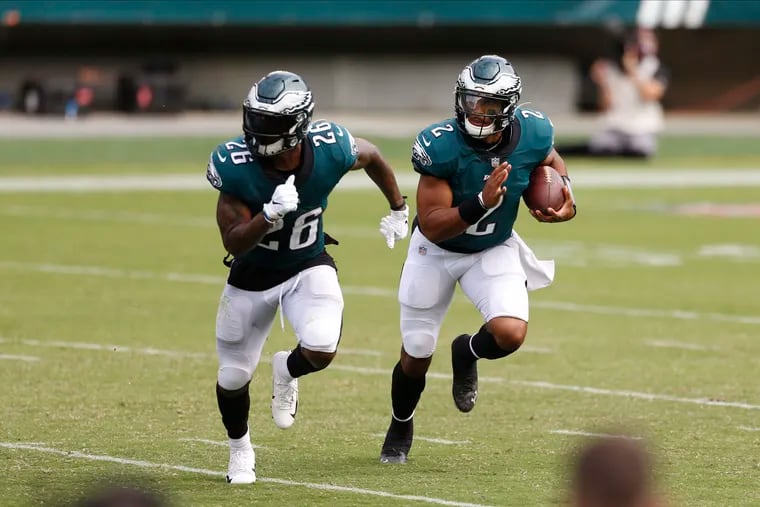 Jalen Hurts (right) carries with Miles Sanders out in front in the Eagles' 23-23 tie against the Bengals.