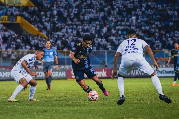 Joaquín Torres (center) controls the ball between two Alianza players ball during the first half.