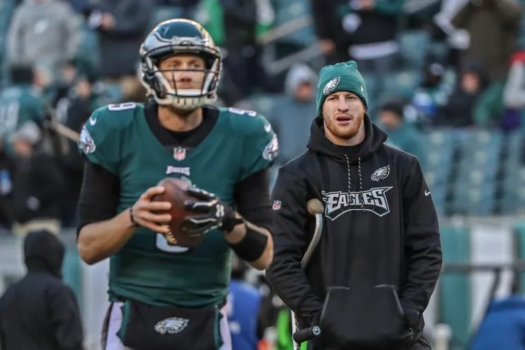 Injured Eagle quarterback Carson Wentz, right, watches starting quarterback Nick Foles, left, warm up prior to the NFC Divisional playoff game against Atlanta on Saturday January 13, 2018. MICHAEL BRYANT/ Staff Photographer